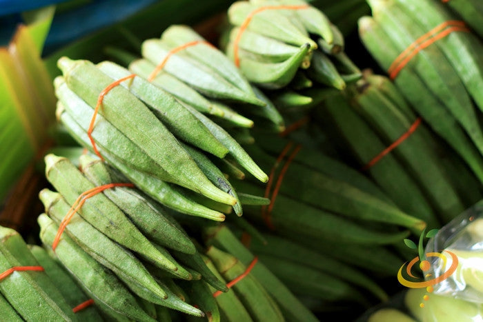 Emerald green velvet okra seeds from SeedsNow, close-up of seed packet showing vibrant seeds for planting.
